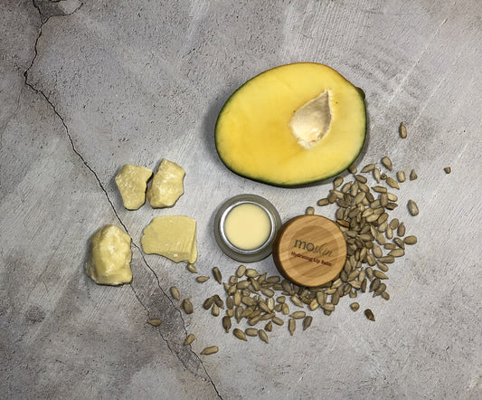 A close-up of freshly exfoliated lips as a fingertip applies a hydrating balm layer that gives a soft, comfortable sheen.